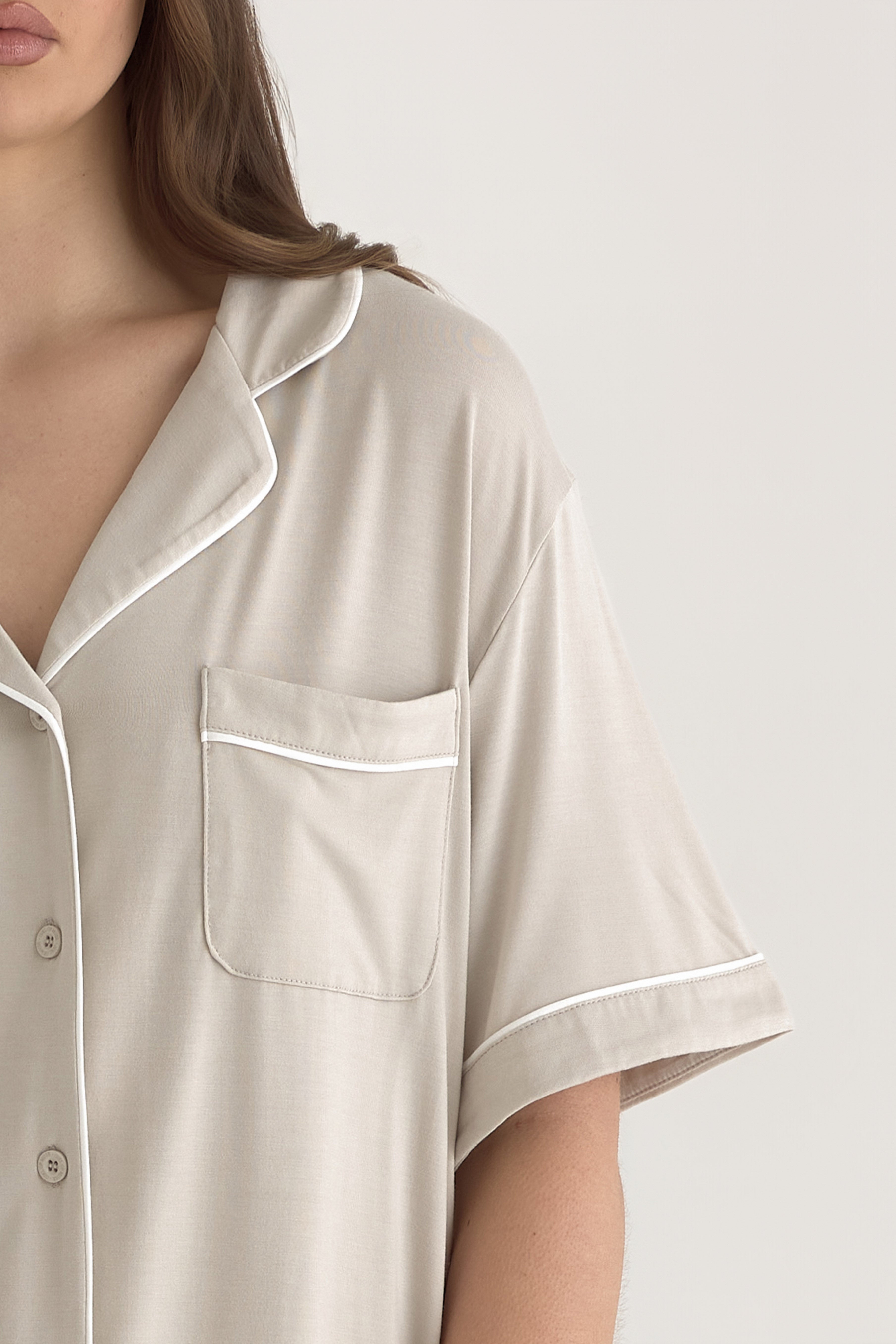 Muse Short PJs — Dusk:  Beige short-sleeve pajama set with white piping detail, featuring a collared shirt and chest pocket.