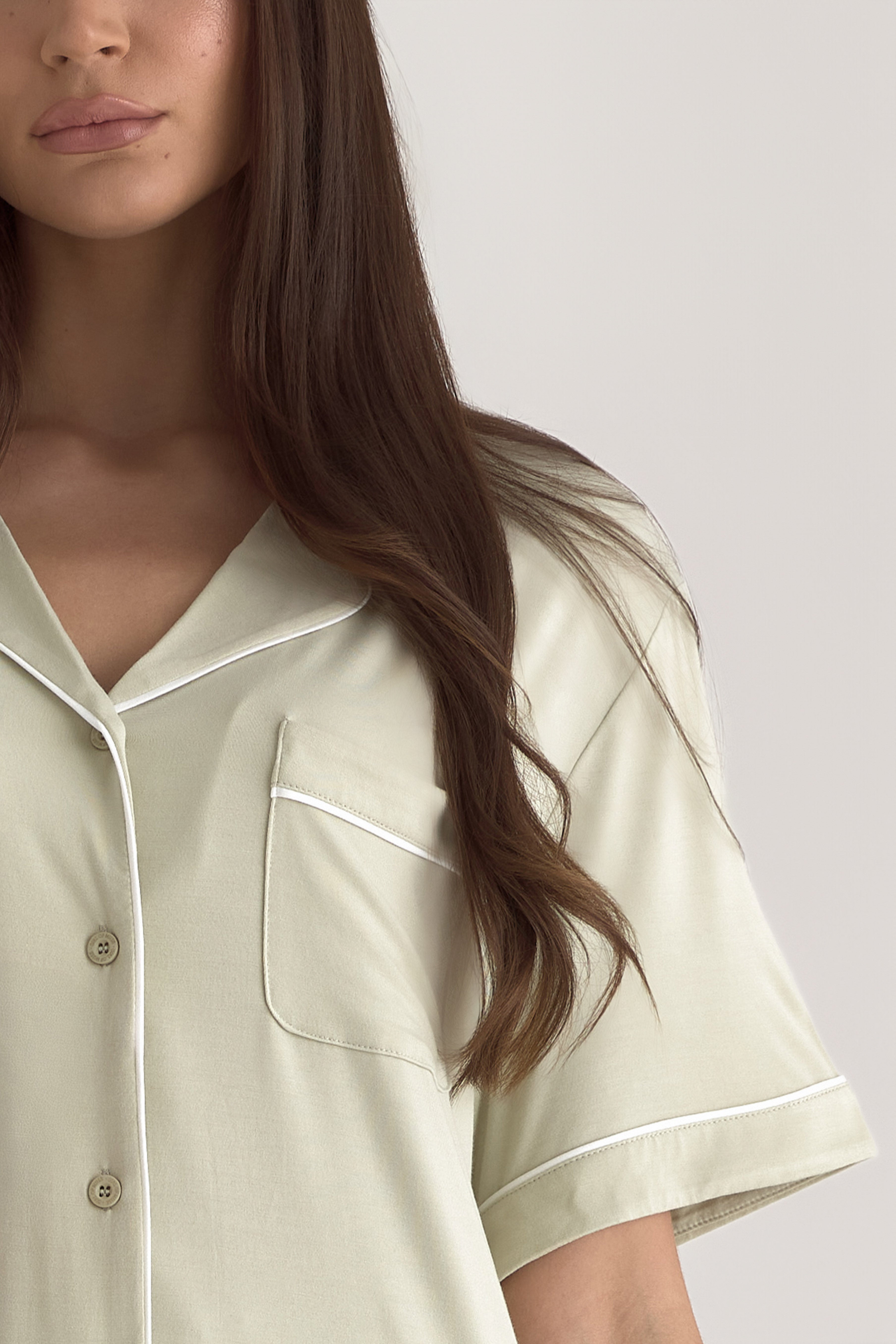 Muse Short PJs in Soft Sage: Close-up of soft sage green pajama top with white piping detail